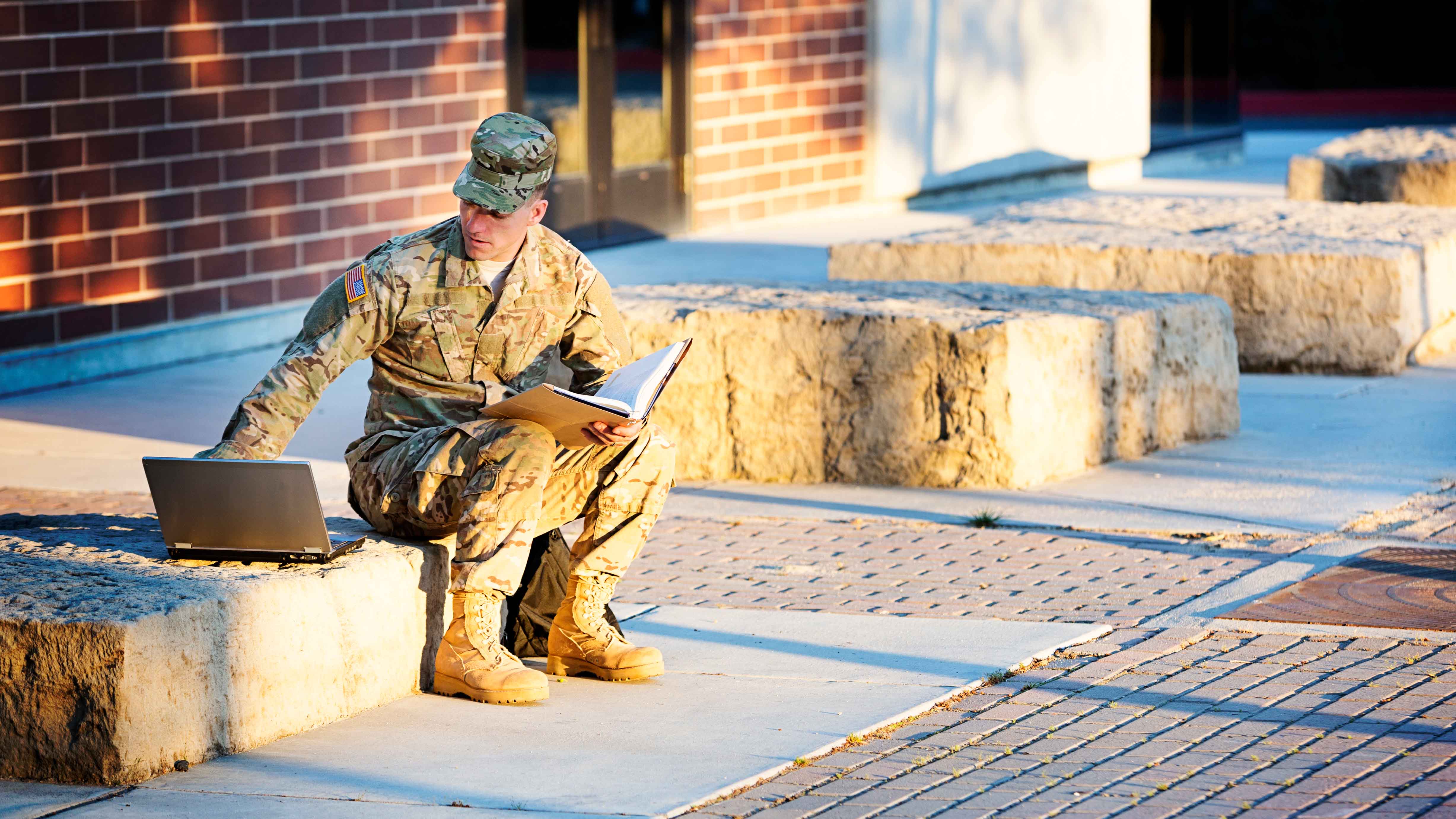 Soldier sitting outside with a laptop