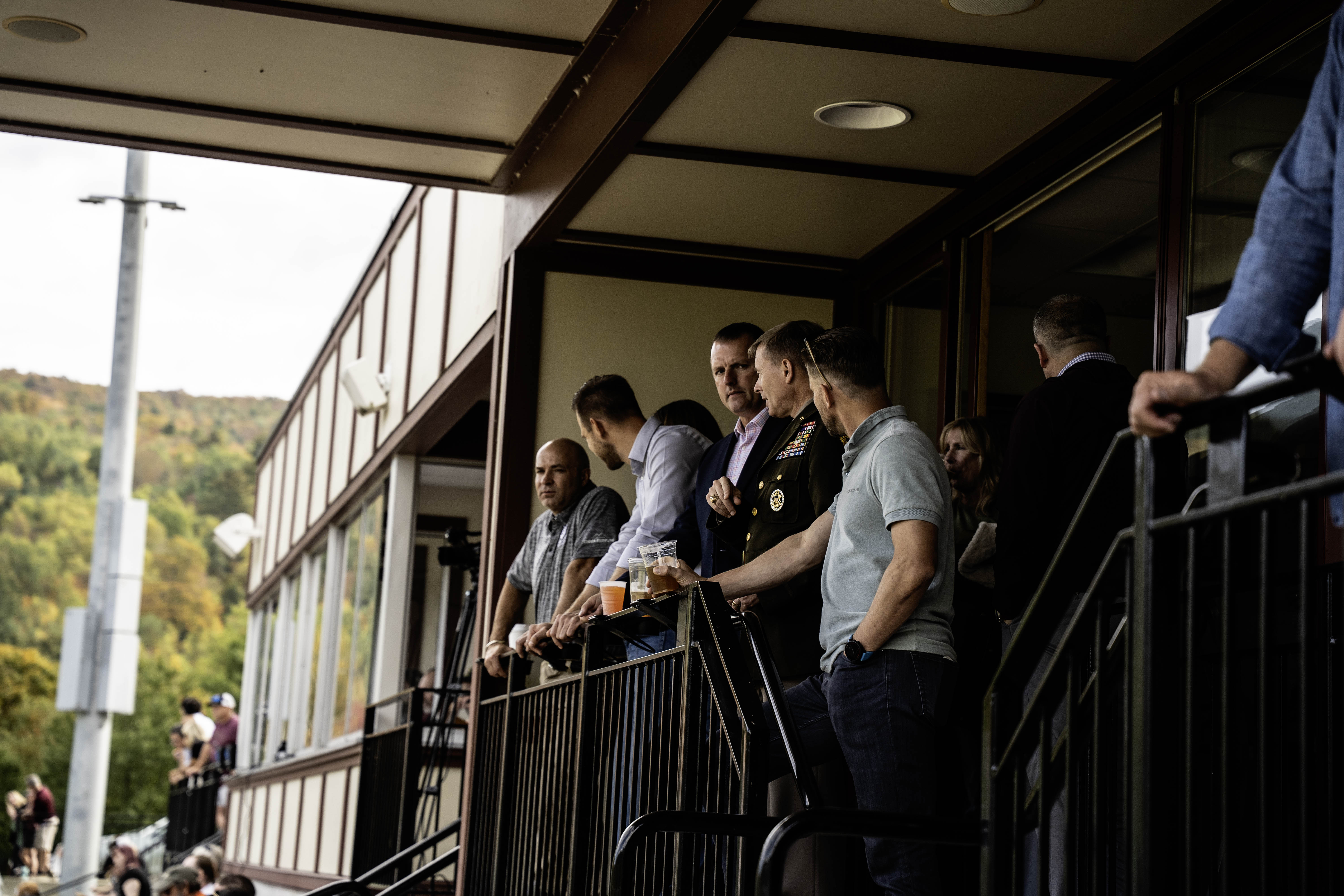 A group of military, Norwich, and NATO officials enjoy a football game from the President's Box.