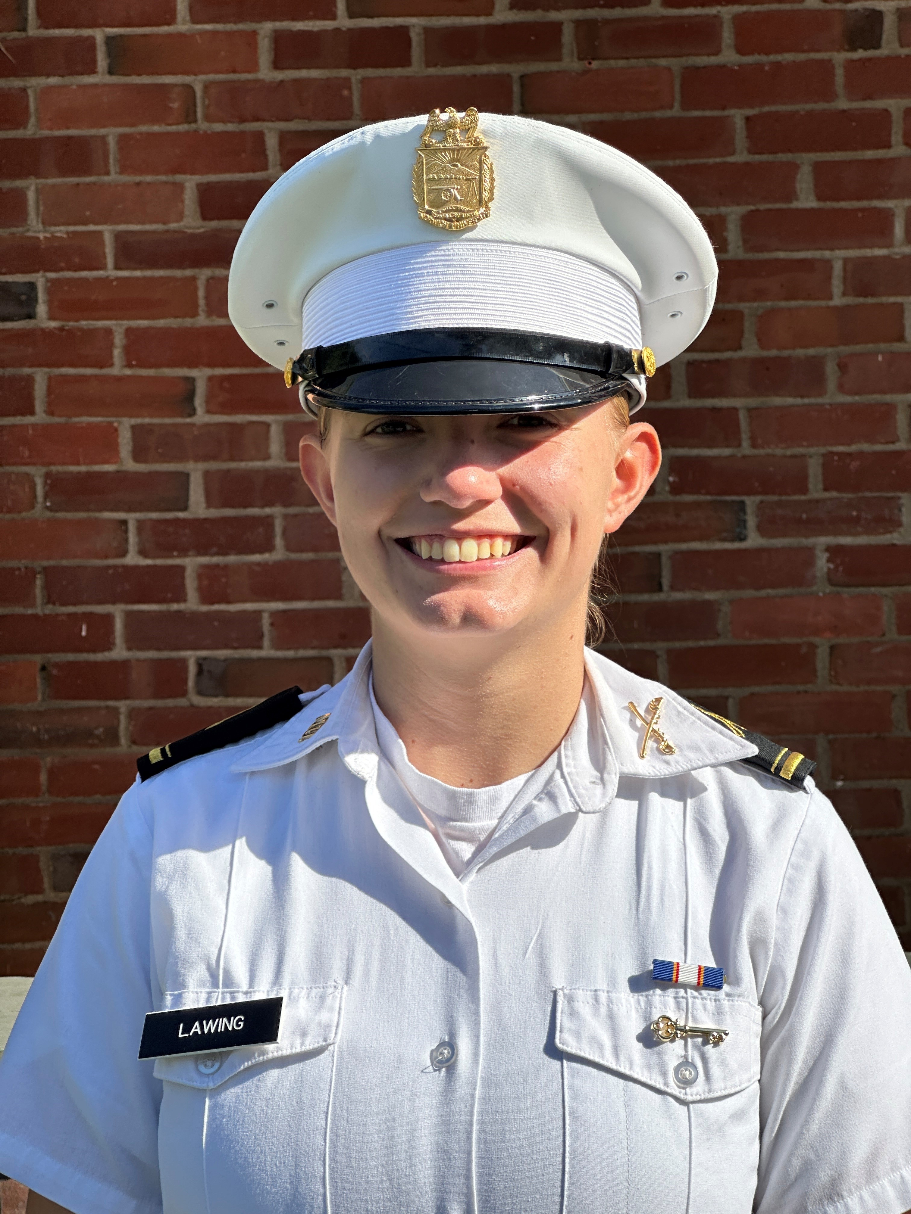A woman smiles in her white uniform in a standard portrait shot.