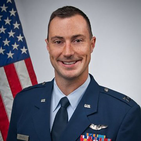 A man in his Air Force uniform smiles in professional headshot.