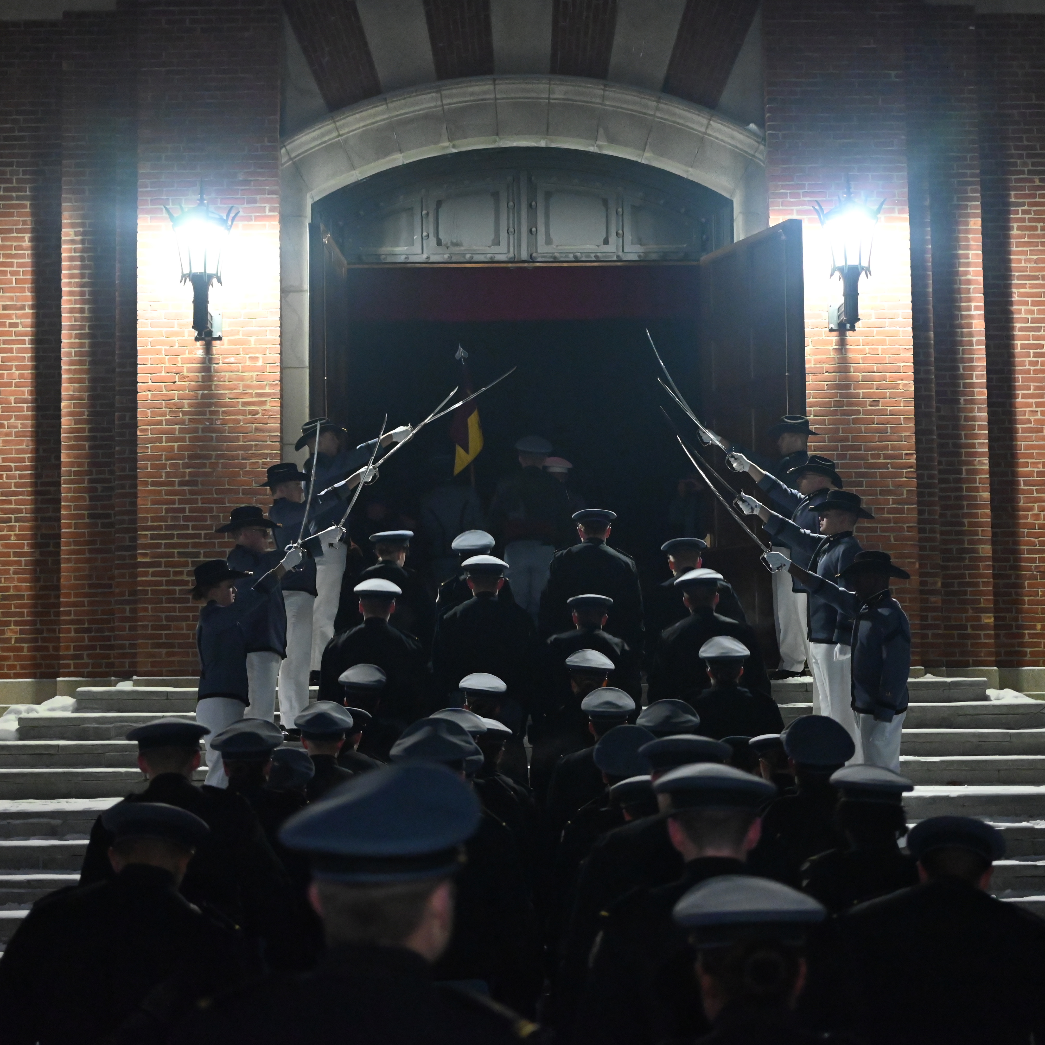 Rooks walk into a building under an archway of drawn swords.