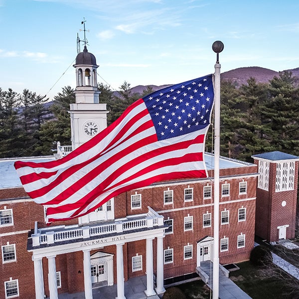 North University Jackman Hall with large American Flag flying in the foreground