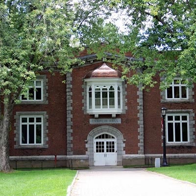 Chaplin Hall's brick facade features a white entrance, arched windows, and trees.