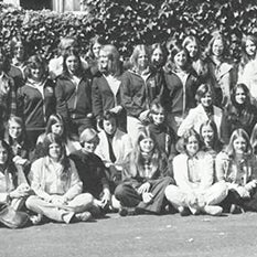 A large group of people pose together outdoors in a black-and-white photograph.