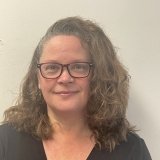 woman with glasses in black shirt