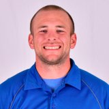 Person wearing a blue collared shirt over a blue T‑shirt.