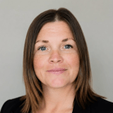 Portrait of a person against a plain gray background.