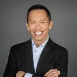 Hansen in suitcoat and blue shirt with arms crossed