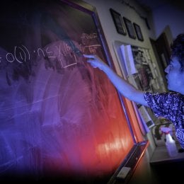 Student writing problem on chalkboard