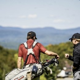 A shot from behind as cadet golfers walk the golf course.