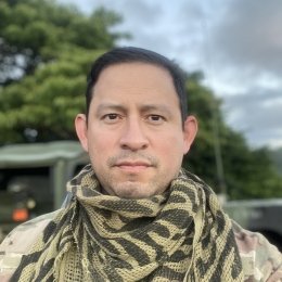 A headshot of Daniel Fienco in camouflage, while outdoors.