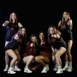 Volleyball players pose against a black background.