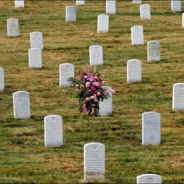 Image of graves at Arlington national cemetery and a wreath of flowers. 