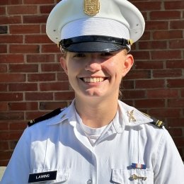 A woman smiles in her white uniform in a standard portrait shot.