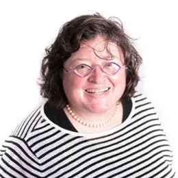 A woman smiles in a formal headshot with a white background.