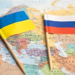 Russian and Ukrainian flag over map of Europe.