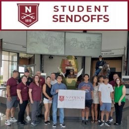 A small group of young adults stand in middle surrounded by older adults. Two in middle hold up a modestly sized white banner reading "Norwich University". Below this photo is a Norwich "N" shield logo and text: Student Sendoffs