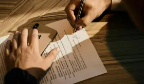 Hands signing document