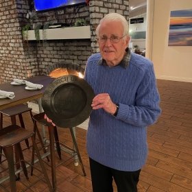 Dave Luce '54 holds his brother's melted award which he salvaged from the Palisades Fires.