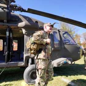 BG Adam Cobb steps off of a Black Hawk Helicopter.