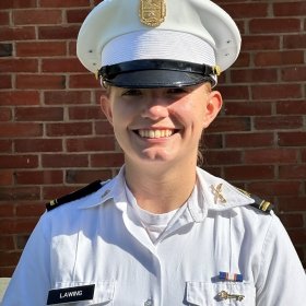 A woman smiles in her white uniform in a standard portrait shot.
