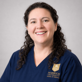Person wearing glasses and navy Norwich School of Nursing scrubs.