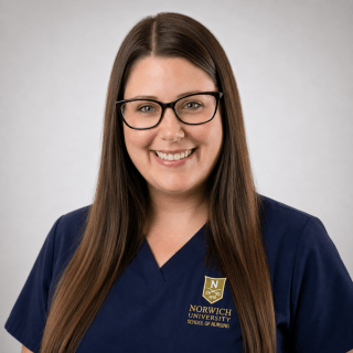 Person wearing navy Norwich University School of Nursing scrubs and glasses.