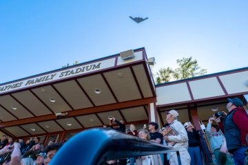 A B-2 Spirit bomber flies over the Norwich University Homecoming crowd