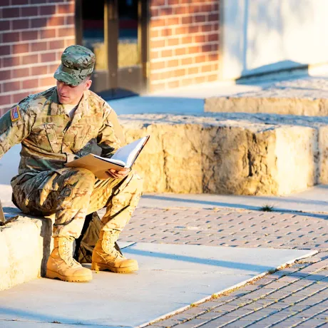Soldier sitting outside with a laptop