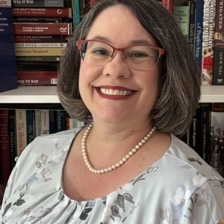 A standard professional headshot of Lisa Mundey in front of a bookcase.