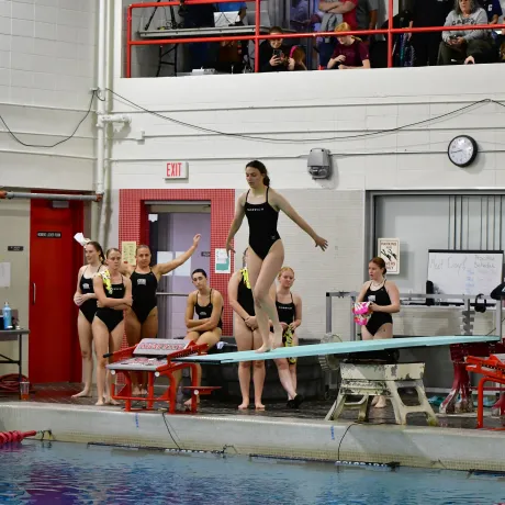Ava LePage prepares to dive from the diving board.