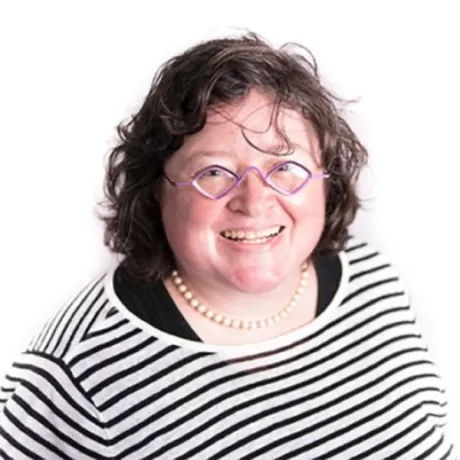 A woman smiles in a formal headshot with a white background.