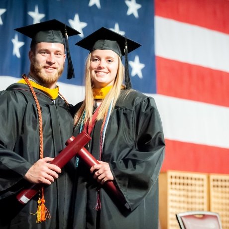 recent Norwich University Graduates on stage receiving diplomas