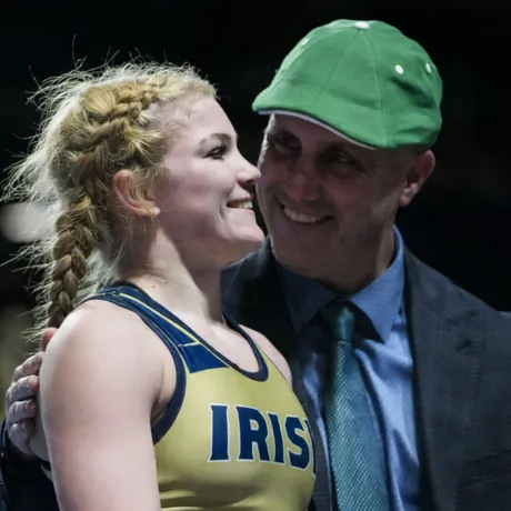 A wrestler and her coach celebrate during an event.