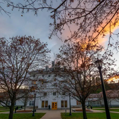 Kreitzberg Library stands behind leafless trees under a colorful evening sky