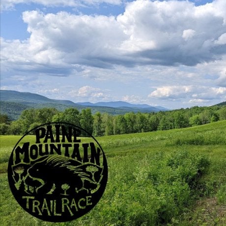 Paine Mountain Trail Race (logo) with field, mountain ranges and sky in background