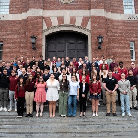 Large group of students pose on the steps outside Plumley Armory.
