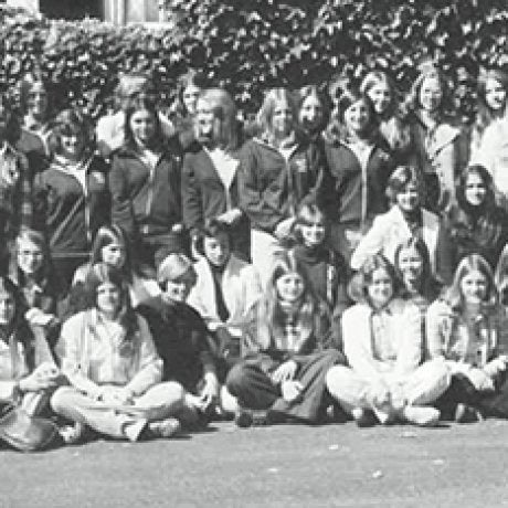 A large group of people pose together outdoors in a black-and-white photograph.
