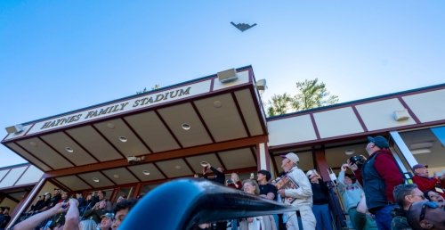 A B-2 Spirit bomber flies over the Norwich University Homecoming crowd