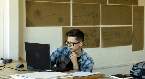 Architecture student working on his computer inside Norwich's studio classroom.