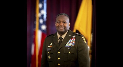 Commandant COL Mark A. Denton '97 Profile image in full dress uniform, flags in background