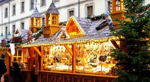 A brightly-lit market stand appears in front of a city block.