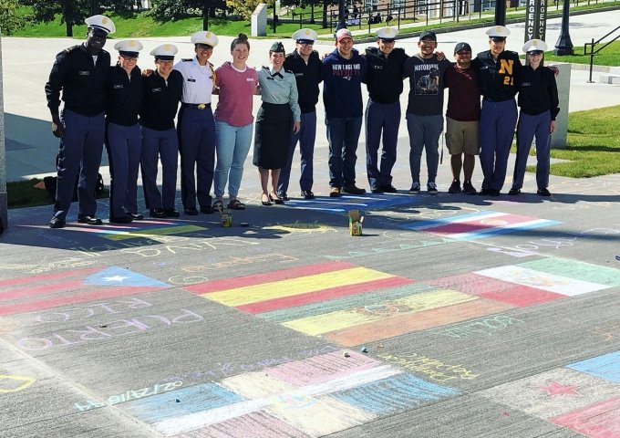 Norwich University students stand by chalk drawings they made outside White Memorial Chapel for Hispanic Heritage Month in September 2022