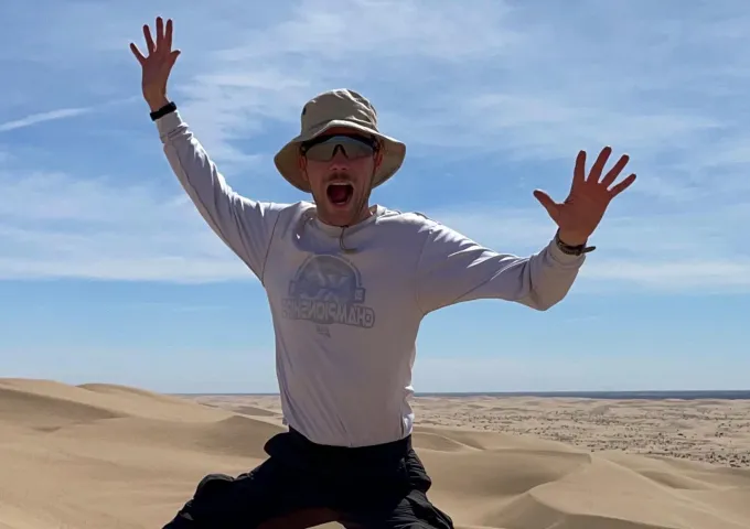 Ethan Moore jumping in the middle of a desert on an Environmental Science trip.