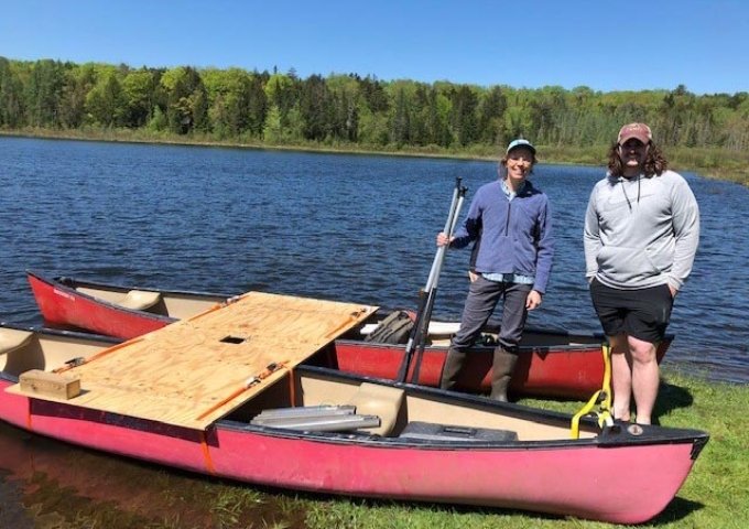 Professor Griggs and student on the lake with canoes.