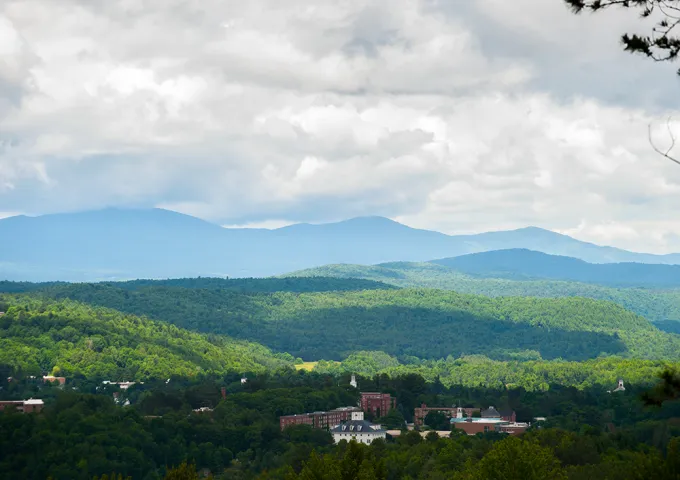 Aerial view of Norwich campus with Green Mountains in the background in the summertime.