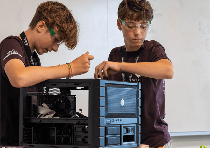 Two students working on a computer modem together.