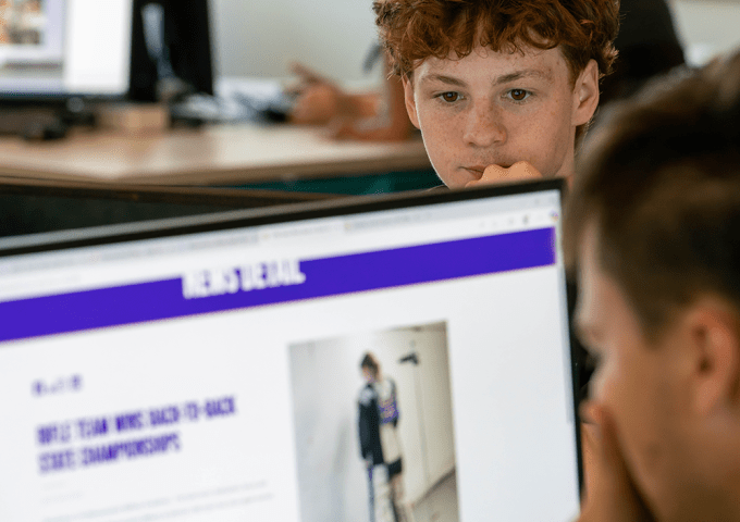 Two students are working on their computers at cyber summer camp.