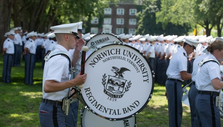 Norwich University Regimental Band drummer standing on the UP surrounded by the Corps of Cadets.