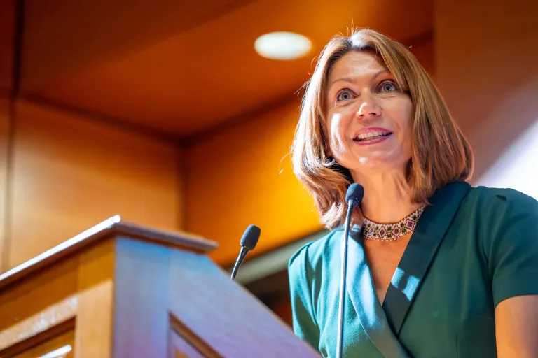 2024 Colby Award winner Mariana Budjeryn speaks at a podium to the crowd at the Military Writers' Symposium.